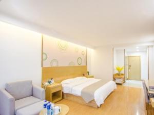a bedroom with a large white bed and a couch at GreenTree Inn Xingxincheng Town Jiayuan Central Plaza Business Hotel in Jiaxing
