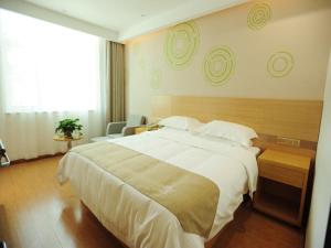 1 dormitorio con cama grande y ventana grande en GreenTree Inn Baoding Qingyuan District Jianshe North Road Express Hotel en Baoding