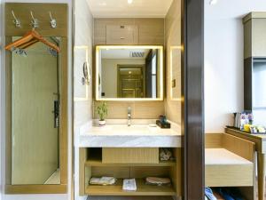 a bathroom with a sink and a mirror at GYA Langfang Art Avenue International Airport Hotel in Langfang