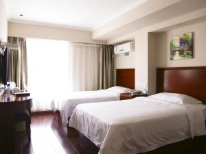 MingguangにあるGreenTree Inn Anhui Mingguang Chihe Avenue Guancheng International City Express Hotelのベッドが2つと窓があるホテルの部屋