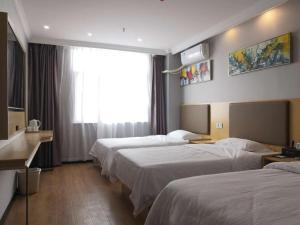 a hotel room with three beds and a window at GreenTree Inn AnHui FuYang Railway StationW) XiangYang Road Business Hotel in Fuyang