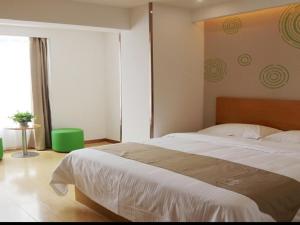 a bedroom with a large bed and a large window at GreenTree Inn Jinan Licheng District Fenghuang Road High-speed Railway East Station Express Hotel in Hongjialou
