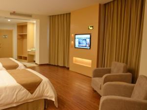 a hotel room with a bed and a flat screen tv at Vatica Xuzhou Suining Bus Station Bayi West Road Hotel in Suining