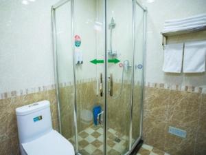 y baño con ducha de cristal y aseo. en Green Alliance Langfang Xianghe County Xiushui Street PengDa furniture city Hotel, en Langfang