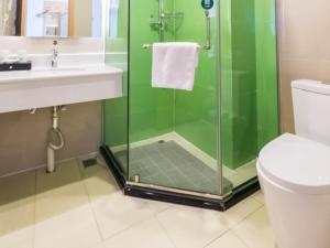 a bathroom with a shower and a sink and a toilet at GreenTree Inn Binzhou Yangxin County Bus Station Lubei Da Market Business Hotel in Binzhou