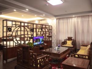a living room with a table and a tv in a room at GreenTree Inn Langfang Dacheng County Donghuan Road Express Hotel in Daicheng