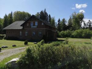 chata Švýcarský dvůr في جانسك لازني: منزل خشبي كبير في حقل به أشجار
