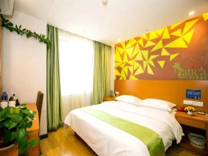 Un pat sau paturi într-o cameră la GreenTree Hospitality Group Ltd Vatica Jiuquan West Han Shengsheng Shengshi Hotel