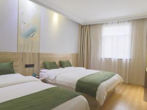 Llit o llits en una habitació de GreenTree Inn JiangSu HuaiAn West JinHu Road BaSi Plaza Express Hotel