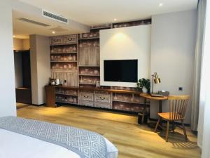 a room with a television and a table and a chair at GME Rizhao Jinan Road Sun Plaza Hotel in Rizhao