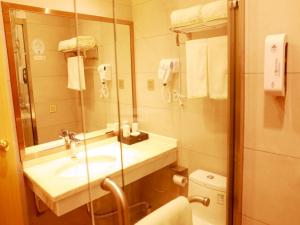 a bathroom with a sink and a mirror and a toilet at GreenTree Inn Suzhou Yongqiao District Suma Park Suzhou Avenue High-speed Railway Station Business Hotel in Suzhou