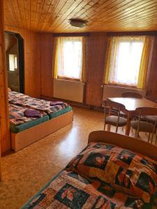 1 dormitorio con 2 camas, mesa y sillas en chata Švýcarský dvůr, en Janske Lazne