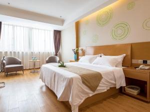 a hotel room with a large bed and a desk at GreenTree Inn Wuxi Jiangyin City Renmin East Road Liangchen Square Business Hotel in Jiangyin +14 photos