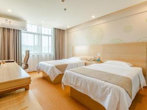 um quarto de hotel com duas camas e uma janela em GreenTree Inn LiuAn Huoshan County Yingjia Avenue County Hospital Express Hotel em Huoshan