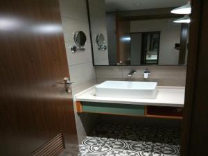 W łazience znajduje się umywalka i lustro. w obiekcie GME Huainan Tianjiaan District Chaoyang East Road Hotel w mieście Huainan