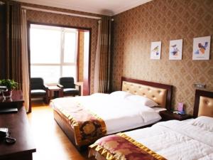pokój hotelowy z 2 łóżkami i oknem w obiekcie Shell Jinzhong Pingyao Ancient City East Gate Hotel w mieście Pingyao