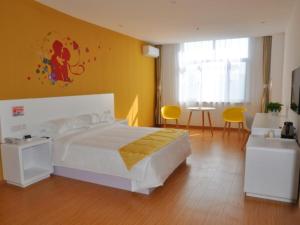 1 dormitorio con cama blanca y pared amarilla en Shell Shangxi Xinzhou Dai County 108 State Road Hotel, en Dai