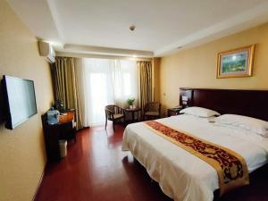 a bedroom with a large bed in a hotel room at GreenTree Inn Hebei Xingtai Railway Station Business Hotel in Xingtai