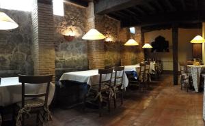 a dining room with tables and chairs and lights at Casa Rural con encanto "Los Postigos" in Baños de Montemayor
