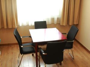 einen Konferenzraum mit einem Tisch und 4 Stühlen in der Unterkunft GreenTree Inn JiangSu WuXi West Jiefang Road Chongan Temple Business Hotel in Wuxi