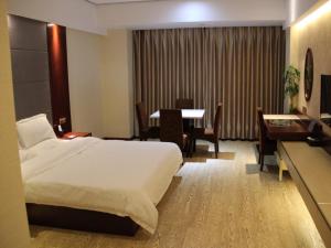 ein Hotelzimmer mit einem Bett und einem Esstisch in der Unterkunft GreenTree Inn Jiangsu Nantong Tongzhou Shiji Avenue Jianghaihuangdu Express Hotel in Tongzhou