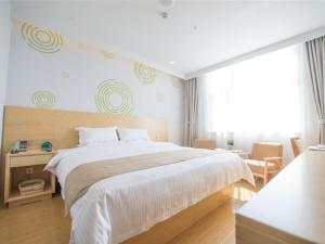 1 dormitorio con cama grande y ventana grande en GreenTree Inn Langfang City Wen'an County Beach Town Anzu Road Business Hotel, en Wen'an