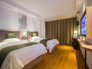 a hotel room with two beds and a flat screen tv at GreenTree Inn Haikou Haixiu Middle Road in Haikou