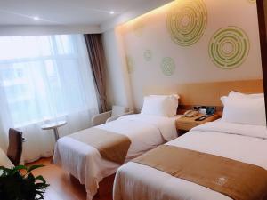 a hotel room with two beds and a window at GreenTree Inn Tangshan Road North District Xishan Road Business Hotel in Tangshan