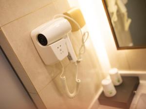 a phone hanging on a wall in a bathroom at GreenTree Inn Fuyang Yingquan District Lanshan Road Linyi Mall Express Hotel in Fuyang