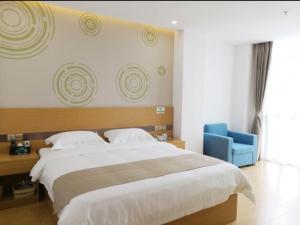 een slaapkamer met een groot bed en een blauwe stoel bij GreenTree Inn Shangrao Guangfeng District Huaxi Auto Trade City Business Hotel in Shangrao