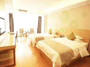 ein Hotelzimmer mit 2 Betten, einem Tisch und Stühlen in der Unterkunft GreenTree Inn Suzhou Yongqiao District Fuxiao Avenue Hotel in Suzhou