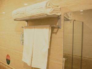 a towel rack in a bathroom with towels at GreenTree Alliance Texas Plain County Ping An East Avenue Hotel in Dezhou