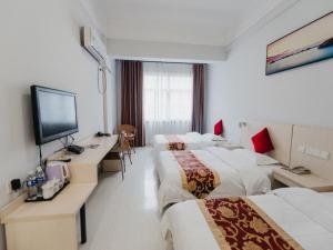 Cette chambre comprend 3 lits et une télévision à écran plat. dans l'établissement Shell Luoyang Lijingmen Mingtang Hotel, à Luoyang