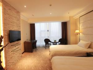 a hotel room with two beds and a flat screen tv at GreenTree Inn ShanDong North WeiHai StationNorth International Bathing Beach Business Hotel in Weihai