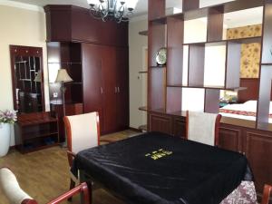 a dining room with a table and a bedroom at GreenTree Inn Shandong Dongying Xisi Road Huachuang Building Business Hotel in Dongying