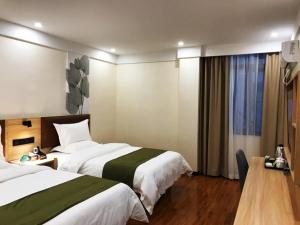 een hotelkamer met 2 bedden en een raam bij GreenTree Inn Huangguoshu Waterfall Scenic Spot Hotel in Anshun