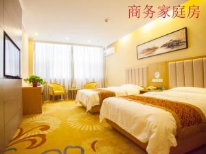 a hotel room with two beds in a room at GreenTree Inn Jiangsu Yancheng Dongtai Huiyang Road Guofu Business Hotel in Dongtai