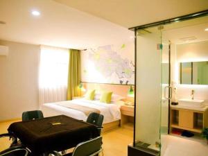 a hotel room with a bed and a sink at Vatica Fuyang Linquan County Jiangziya Square Hotel in Fuyang