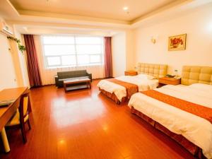 Habitación de hotel con 2 camas y escritorio en GreenTree Alliance Texas Plain County Ping An East Avenue Hotel, en Dezhou