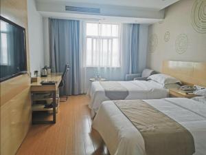 a hotel room with two beds and a desk at GreenTree Inn LuAn Yeji District Yeji Railway Station Express Hotel in Sifangtang