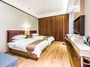 1 dormitorio con 2 camas, escritorio y TV en Gya Hangzhou Linan Qingshan Lake Science City Hotel, en Hangzhou
