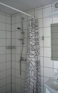 a bathroom with a shower with a shower curtain at Hiiumaa Ametikooli Accommodation in Suuremõisa