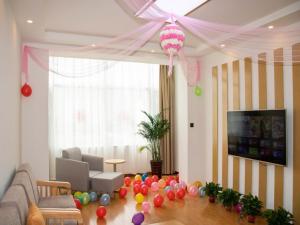 a living room with balloons on the floor and a television at GreenTree Inn Shijiazhuang Yuanshi County Beihuan Road in Shijiazhuang