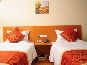een hotelkamer met 2 bedden met rode en witte lakens bij GreenTree Inn HeBei LangFang YanJiao Tianyang Plaza Express Hotel in Maqifa