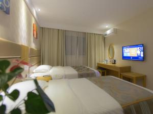 ein Hotelzimmer mit 2 Betten und einem Flachbild-TV in der Unterkunft GreenTree Inn JiangSu XuZhou JiaWang Government Express Hotel in Xuzhou