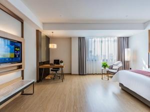 a hotel room with a bed and a desk at Gya Jiaxing City Haiyan County Chang'an South Road Lishi Plaza Hotel in Jiaxing