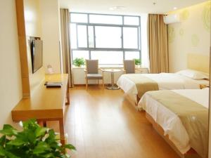 Una habitación de hotel con dos camas, una mesa y una ventana. en GreenTree Inn Wuxi Huishan District Yangshan Town Jiayang Life Plaza Business Hotel, en Wuxi