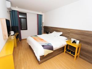 pokój hotelowy z dużym łóżkiem i stołem w obiekcie Shell Liu'an Wanxi Avenue International Motor City Hotel w mieście Lu'an