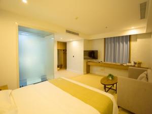 a hotel room with a large bed and a chair at GreenTree Inn Liao Cheng Shen Country Bus Station Business Hotel in Liaocheng