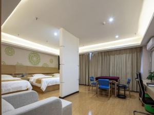 um quarto de hotel com duas camas e uma mesa e cadeiras em GreenTree Inn Changzhou Menghe Town Chengfeng Building Business Hotel em Changzhou
